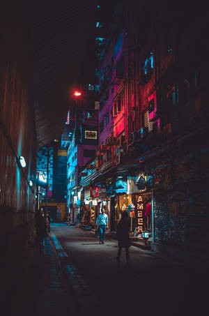 夜晚的城市小巷，霓虹燈和行人走在濕漉漉的人行道上。 — 藝術 壁紙