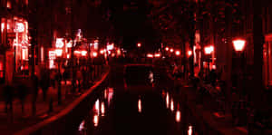 夜晚紅色燈光的運河，帶有倒影和行人剪影。 — 夜景城市 壁紙