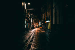 夜晚黑暗的城市街道，有發光的路燈和濕漉漉的鵝卵石。 — 暗夜城市 壁紙