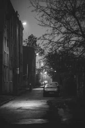 夜晚一條燈光昏暗的城市小巷，有停泊的汽車和光禿禿的樹木。 — 小米Mix 壁紙
