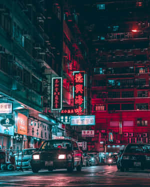 霓虹招牌在夜晚潮濕的城市街道上發出紅藍光芒，的士經過。 — 夜景城市 壁紙