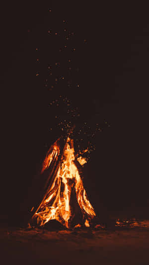 夜晚嘅營火，火花向上飛舞。 — 暮光 壁紙