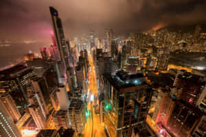 夜晚的城市景觀，有照明摩天大樓和發光的街道。 — 日落大道 壁紙
