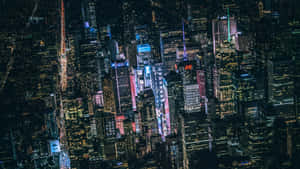 密集城市天際線的夜間鳥瞰圖，摩天大樓燈火通明，街道閃爍。 — 夜景城市 壁紙