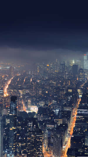 夜晚城市景觀，黑暗雲層下閃爍的建築物和街道。 — 鎖屏 壁紙