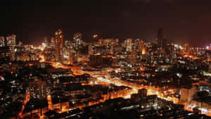 高樓大廈和閃爍街道的密集照明城市夜景。 — 天際線 壁紙
