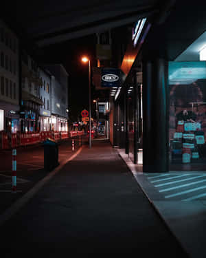 夜晚黑暗的城市小巷，有發光的商店招牌和潮濕的人行道。 — 夜景城市 壁紙