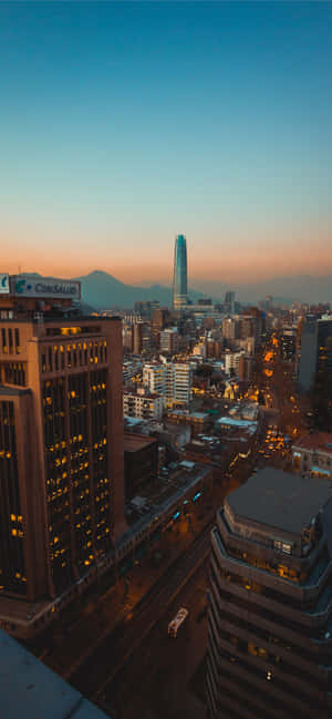 暮色中的聖地牙哥城市景觀，建築物燈火通明，遠山可見。