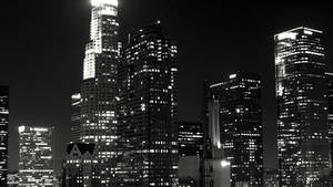 夜間照明摩天大樓的黑白城市景觀。