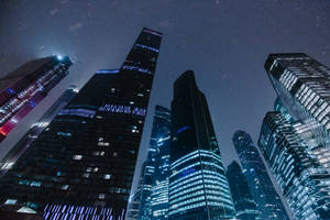 雪天下，燈火通明的摩天大樓夜景。