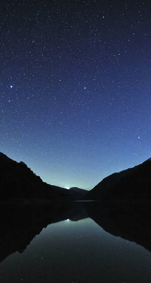星空夜空倒映在寧靜的山湖中。
