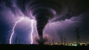 夜間電線上方的龍捲風和閃電，遠處有城市燈光 — 龍捲風 壁紙
