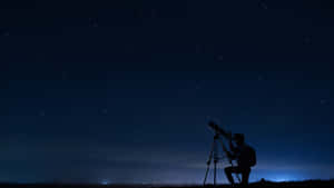 夜間使用望遠鏡觀星的人。 — 夜空 壁紙