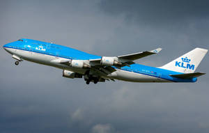 KLM波音747飛機在起落架放下時向多雲天空爬升