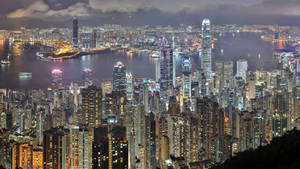 夜間香港天際線，燈火通明的摩天大樓和港口燈光。