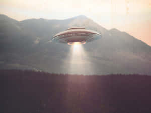 UFO在黃昏時分將光投射在山林上。