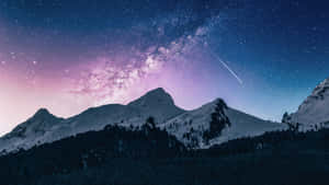 雪覆蓋的山脈在星空下，有銀河和流星。