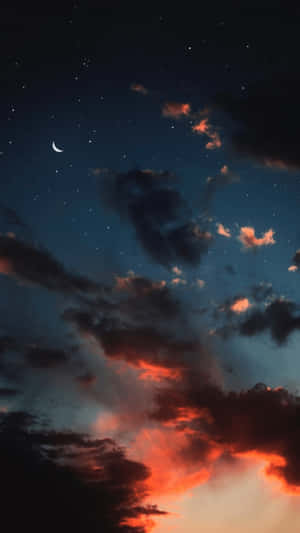 火橙色和藍色暮光雲層上方的新月和星星。