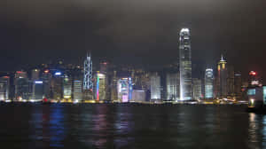 香港夜景，燈火輝煌的摩天大樓倒映在水中。 — iMac 壁紙