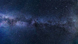 銀河系在漆黑的夜空中散發著紫色和藍色的星光。