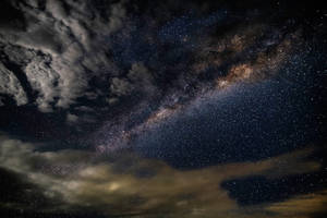 銀河系在繁星點點的夜空中透過烏雲閃耀。 — 夜晚 GIF 壁紙