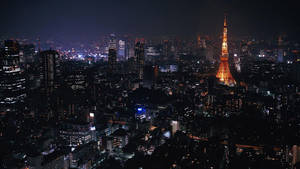 夜間東京城市景觀，東京塔在摩天大樓中亮起。
