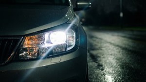 汽車頭燈照亮夜間潮濕的道路