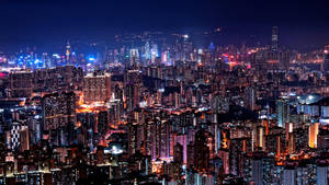 夜晚中，無數燈火通明的建築物與閃爍街道的廣闊城市。
