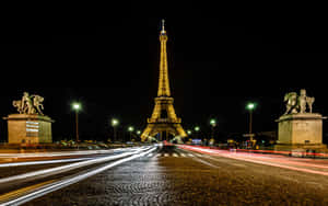 夜晚燈光下的艾菲爾鐵塔，帶有汽車光跡。