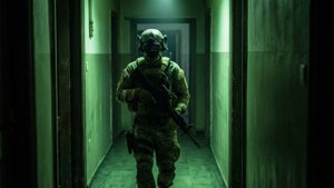 身穿戰術裝備的士兵在昏暗的綠色走廊中持步槍。