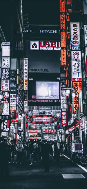 夜晚東京的霓虹燈街道，人群和高聳的招牌。