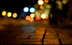 夜晚濕滑的鵝卵石街道，背景有模糊的彩色燈光。