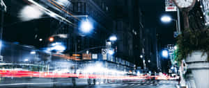 夜晚城市街道，有汽車光軌和高樓大廈。