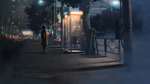 黃昏時分，一個人獨自走在城市人行道上，經過一個發光的電話亭。