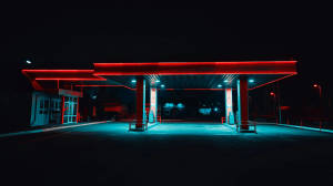 夜晚的現代加油站，被紅色和藍色霓虹燈照亮。 — 夜晚 GIF 壁紙