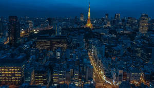 夜晚的東京城市景觀，東京鐵塔亮起，周圍建築物閃爍光芒。