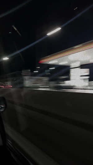 夜間駕車經過加油站，車窗外的燈光掠過。 — 夜晚 GIF 壁紙