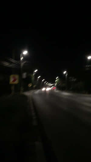 夜間街道場景，街燈和車頭燈呈現動態模糊效果。
