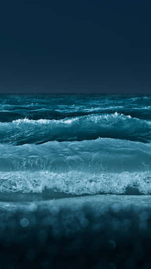 夜間海浪翻滾，前景有散景燈光