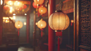 一個發光的紅色燈籠帶有流蘇，掛在一個傳統木走廊中，其他燈籠處於柔和焦點。 — 夜晚 GIF 壁紙