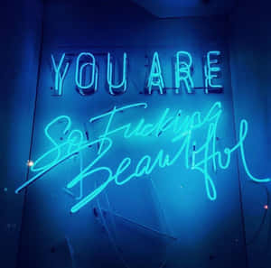 藍色霓虹燈牌，在深色牆壁上以粗體字顯示「YOU ARE So Fucking Beautiful」。 — 霓虹藍色美學 壁紙