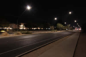 夜晚寧靜的郊區街道，有路燈和房屋。 — 夜晚 GIF 壁紙