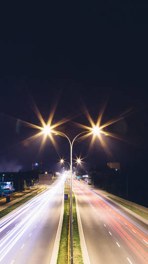 夜間高速公路，車燈光軌和發光路燈。