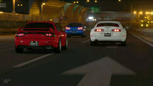 三輛跑車在夜間穿過隧道疾馳，帶有發光的尾燈。