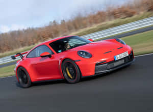 紅色保時捷911 GT3 RS在賽道上奔馳，伴有秋葉。