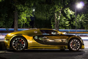金色Bugatti Veyron夜間停泊，樹後有模糊的交通燈光。 — 樹 壁紙