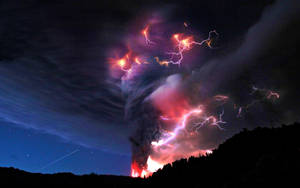 夜間火山爆發，閃電劃過煙霧，熔岩發出紅光。 — 夜晚 GIF 壁紙