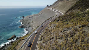 彎曲的沿海公路，汽車沿懸崖行駛，俯瞰海洋