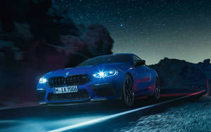 藍色BMW M8 Coupe在星空下山路上疾馳。 — 夜空 壁紙
