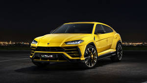 黃色林寶堅尼 Urus SUV 夜間停泊，背景有城市燈光。